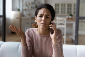 Talking about immigration problems. Sad young hispanic female hold phone to ear discuss with immigration lawyer