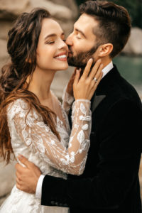 Beautiful wedding couple laugh and kiss