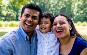 Latino parents with their son, smiling and laughing