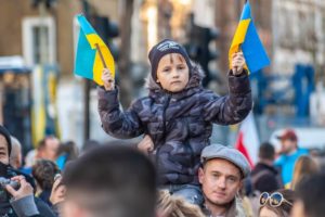 Child holding Ukranian flags outside Downing Street whilst protesting against Russia's invasion of Ukraine