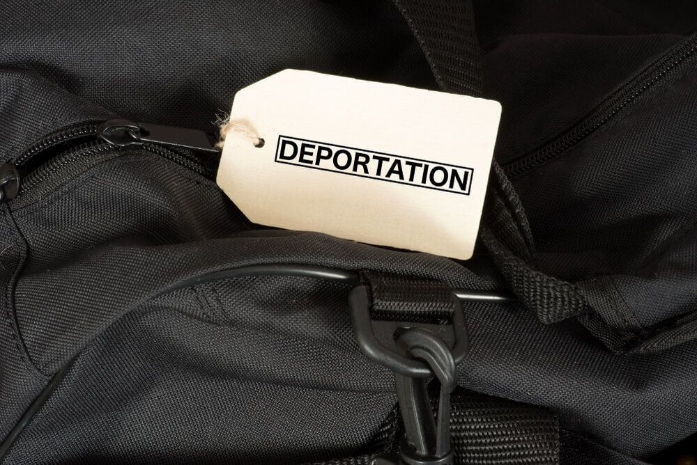 A bag and a sign with the word Deportation